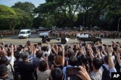 Người dân Singapore chụp hình và đồng thanh lên tiếng 'Cám ơn ông Lý' trong lúc quan tài chở linh cữu ông được đưa đến trụ sở Quốc hội, ngày 25/3/2015.