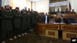 Forty-nine defendants left, attend their trial at the Primary Court in Kabul, Afghanistan, on charges related to the mob killing of an Afghan woman, May 2, 2015.