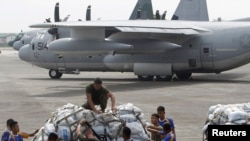Nhân viên quân đội Mỹ và Philippines đưa hàng cứu trợ lên máy bay vận tải C-130 để chở tới miền trung Philippines từ căn cứ không quân Villamor tại Manila, ngày 11/11/2013.