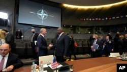U.S. Defense Secretary Lloyd Austin, center-right, speaks with Dutch Defense Minister Henk Kamp, center-left, ahead of a meeting of NATO defense ministers at NATO headquarters in Brussels, Oct. 21, 2021.