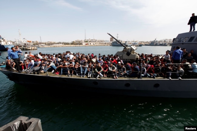 FILE - Illegal migrants arrive by boat at a naval base after they were rescued by Libyan coastguard in the coastal city of Tripoli, Libya, May 10, 2017.