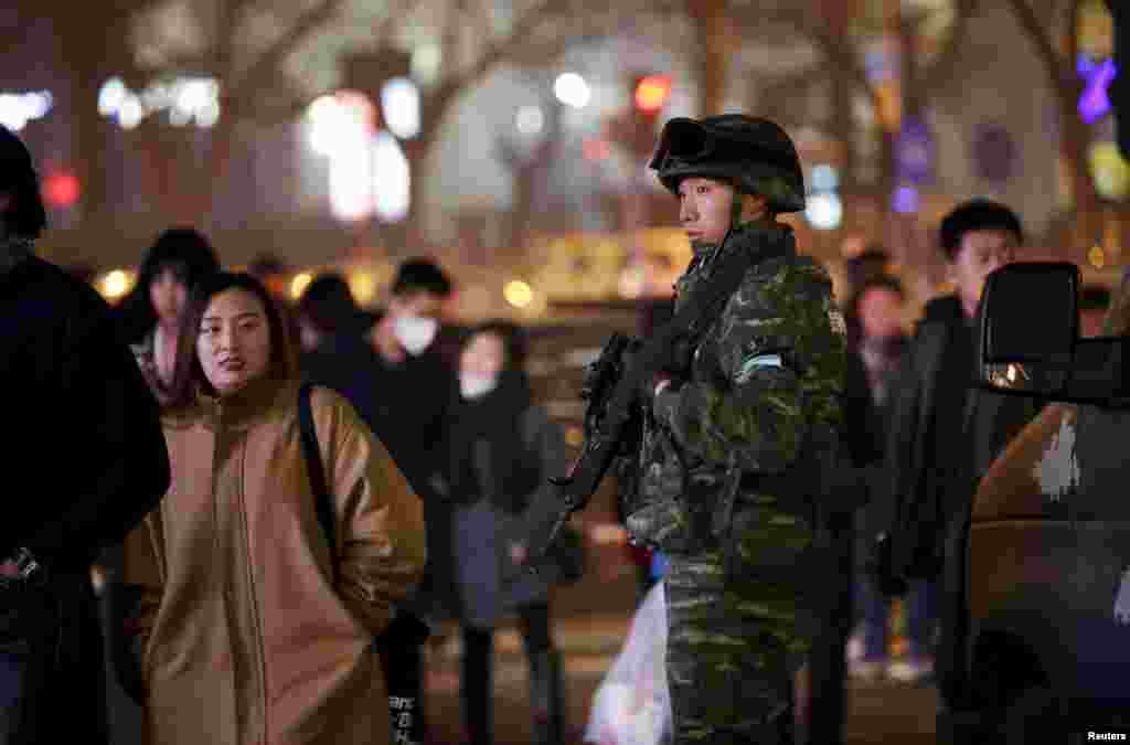 2015年12月24日，北京圣诞节前夕，在时尚的购物和餐饮区三里屯，人群熙熙攘攘，持枪武警巡逻。 此前美英等国驻京使馆对侨民发出警告称，圣诞节前后在北京三里屯附近，有可能发生针对西方人的袭击，要提高警惕。
