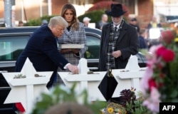 US President Donald Trump and First Lady Melania Trump, alongside Rabbi Jeffrey Myers, place stones and flowers on a memorial as they pay their respects at the Tree of Life Synagogue in Pittsburgh, Pennsylvania