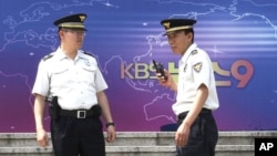 South Korean police officers stand guard in front of the Korea Broadcasting System (KBS) building in Seoul, South Korea, June 4, 2012. 