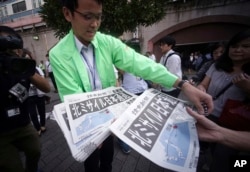 A man distributes an extra edition of a newspaper reporting about North Korea's missile launch, at Shimbashi Station in Tokyo, Sept. 15, 2017.