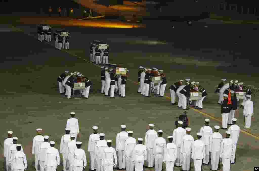 Philippine Marines carry the flag-draped caskets of eight marines who were killed Friday in the battle with Muslim militants in Marawi city in southern Philippines, after being flown in to Villamor Air Force base in suburban Pasay city southeast of Manila.