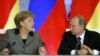 Russian President Vladimir Putin, right, and German Chancellor Angela Merkel speak to each other after a signing ceremony during a Russian-German business forum in the Grand Kremlin Palace in Moscow, Friday, Nov. 16, 2012. 