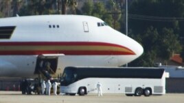 Personnel in biological hazard suits await passengers evacuated from Wuhan, the Chinese city at the heart of a growing outbreak of the deadly Novel Coronavirus shortly after the plane landed at March Air Reserve Base in Riverside, California.