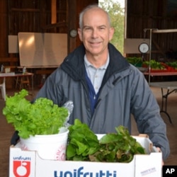 Shareholder Dennis Luther leaves with his weekly supply of fresh, organic vegetables: beets, turnips, peppers,sweet potatoes and greens.