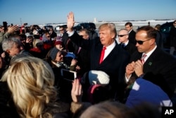 President Donald Trump waves to supporters after arriving at Pittsburgh International Airport, Jan. 18, 2018, in Pittsburgh.