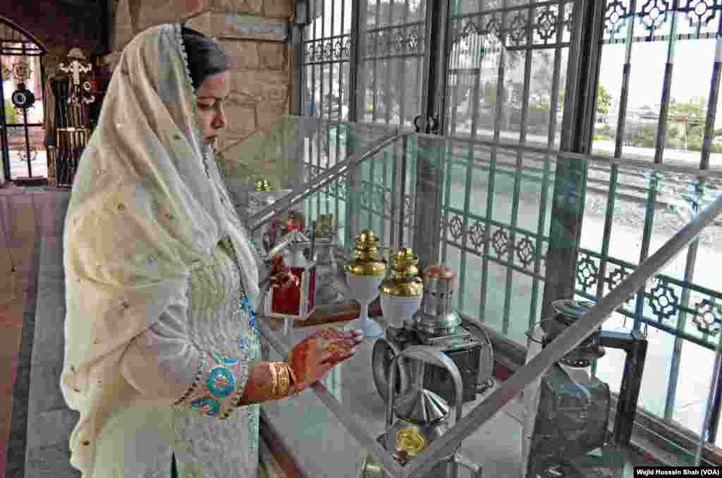 ایک خاتون عجائب گھر کے شوکیس میں رکھی ہوئی چیزوں کو دیکھ رہی ہے۔