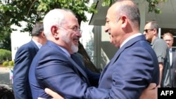 Turkish Foreign Minister Mevlut Cavusoglu, right, welcomes Iranian counterpart Mohammad Javad Zarif at the foreign ministry in Ankara, Aug. 12, 2016.