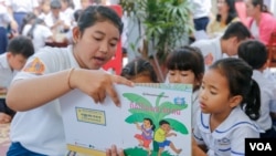 Children are reading during book exhibition in 2nd National Reading Day at National Institution of Education, March 11, 2017. (Khan Sokummono/ VOA Khmer)