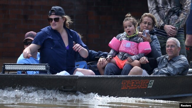 Người dân đi thuyền để sơ tán khỏi khu vực lũ lụt khi trận bão Harvey quét qua khu vực phía tây của Houston, Texas, hôm 30/8.