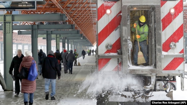 图为芝加哥地铁工作人员在清除积雪（2018年2月9日）