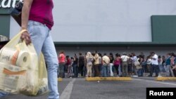 A woman carries bags with toilet paper rolls. 