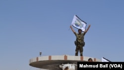 Vitória! Combatente das Forças Democráticas em Manbij