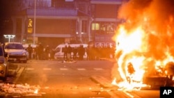 11일 프랑스 파리 외곽에서 경찰에 맞선 시위대가 차량을 불태우고 있다. 