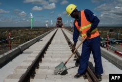 FILE - A Kenyan worker lays gravel at a construction site for the Standard Gauge Railway (SGR) in Nairobi, Kenya, June 23, 2018.