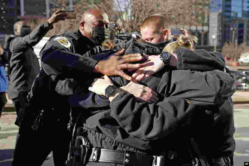 Nashville Police Chief John Drake, left, and a group of police officers hug after speaking at a news conference, December 27, 2020, in Nashville, Tennessee.&nbsp;The officers are credited with evacuating an area before an explosion took place in downtown Nashville early Christmas morning.&nbsp;