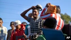 Para migran dari Amerika Tengah antre untuk memulai proses pemulangan ke negara masing-masing dengan bantuan Organisasi Migrasi Internasional, di Tijuana, Meksiko, 26 November 2018.