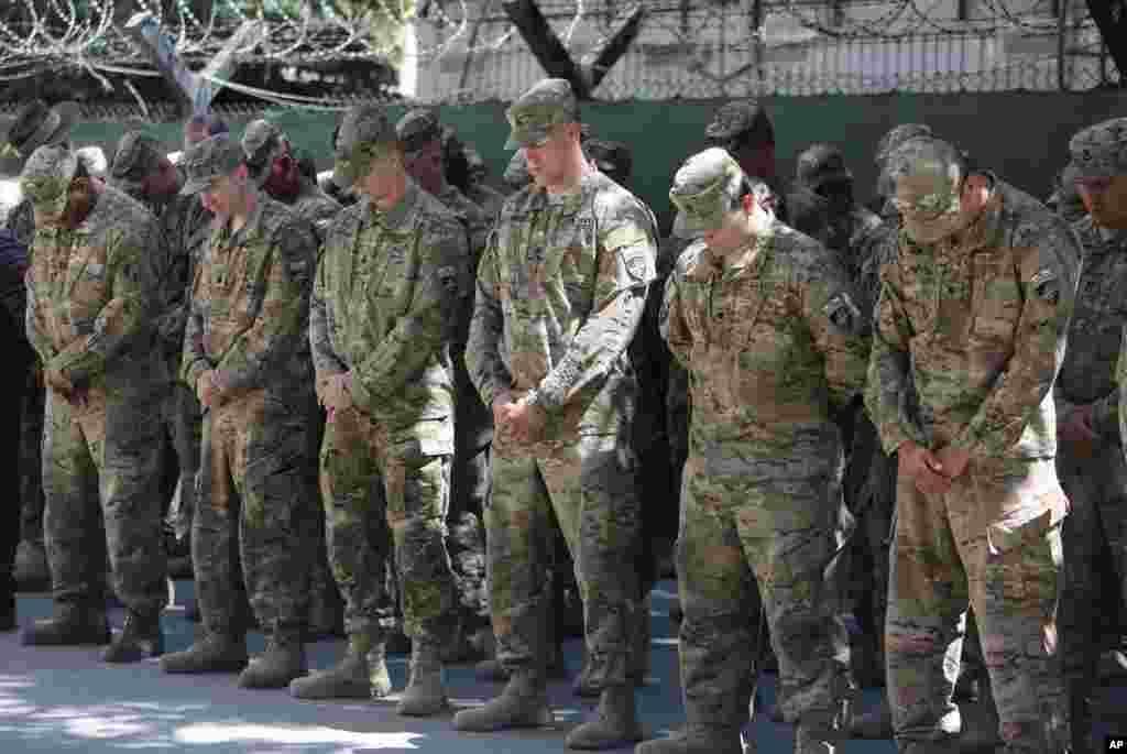 NATO forces observe a moment of silence during a memorial ceremony on the 14th anniversary of the 9/11 terrorist attacks on the United States, at the headquarters of the International Security Assistance Force, in Kabul, Afghanistan, Sept. 11, 2015.