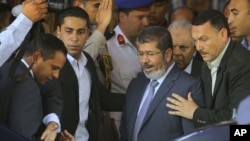 Egypt's President-elect Mohammed Morsi is guarded by presidential security as he leaves Friday prayers at Al-Azhar mosque, in Cairo, Egypt, Friday, June 29, 2012.