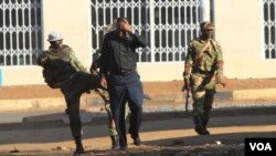 FILE: A soldier assaults a man on the streets of Harare following demonstrations by opposition party supporters.