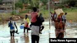 Warga menyebrangi bagian di kota Pemba yang masih terendam banjir di pesisir utara Mozambik, Kamis, 2 Mei 2019 (foto: AP Photo/Tsvangirayi Mukwazhi)