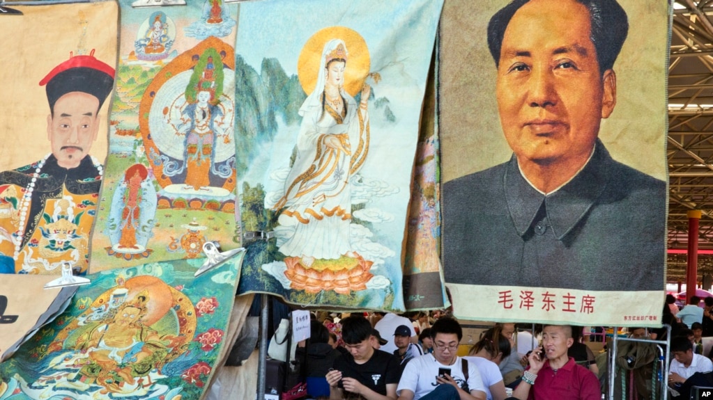 资料照片：文革爆发50周年之际，北京一处古玩市场的商贩坐等顾客前来购买毛泽东像以及摆在一处的帝王和神佛像。(2016年5月16日)(photo:VOA)