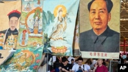 资料照片：文革爆发50周年之际，北京一处古玩市场的商贩坐等顾客前来购买毛泽东像以及摆在一处的帝王和神佛像。(2016年5月16日)