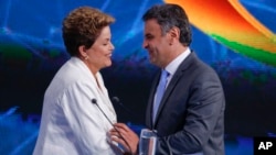 Brazil's President Dilma Rousseff shakes hands with Aecio Neves. Rousseff and Neves will face each other in a presidential runoff on Oct. 26. (AP Photo/Andre Penner)