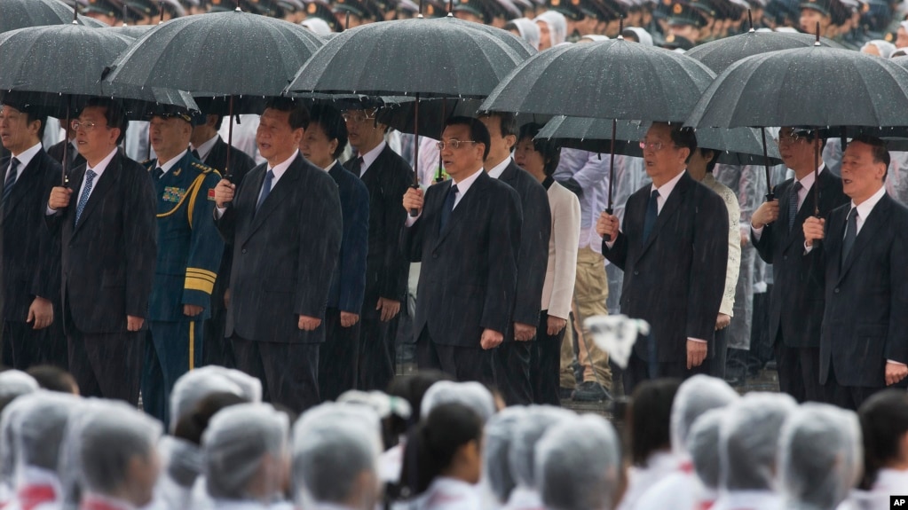 资料照片：中共总书记习近平、中国总理李克强、中共政治局常委张德江、俞正声、王岐山等人在雨中在人民英雄纪念碑前唱国歌。（2013年10月1日）