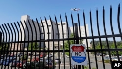 The Federal Detention Center where Blanca Orantes-Lopez is held 3,000 miles away from her child is seen behind a fence as a jet flies overhead, June 19, 2018, in SeaTac, Wash. The woman from El Salvador sits in the federal prison south of Seattle, having reported to immigration authorities after crossing the U.S.-Mexico border illegally in Texas. Her son, Abel Alexander, is in the government's custody at a children's home in Kingston, New York. She has no idea when she might see her child, one of about 2,000 children President Donald Trump's administration has taken from their parents as it cracks down on illegal immigration.