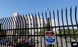 The Federal Detention Center where Blanca Orantes-Lopez is held 3,000 miles away from her child is seen behind a fence as a jet flies overhead, June 19, 2018, in SeaTac, Wash.