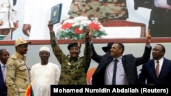 Sudan's Head of Transitional Military Council, Lieutenant General Abdel Fattah Al-Burhan, and Sudan's opposition alliance coalition's leader Ahmad al-Rabiah, celebrate the signing of the power sharing deal. (File)