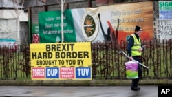 A man walks past republican posters referring to Brexit in West Belfast, Northern Ireland, Feb. 28, 2017. 