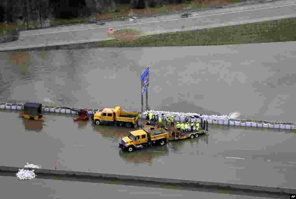 Road crews pump water off the highway as floodwater covers Interstate 55, in Arnold, Missouri, USA. Surging Midwestern rivers forced hundreds of evacuations, threatened dozens of levees and brought transportation by car, boat or train to a virtual standstill in the St. Louis area.