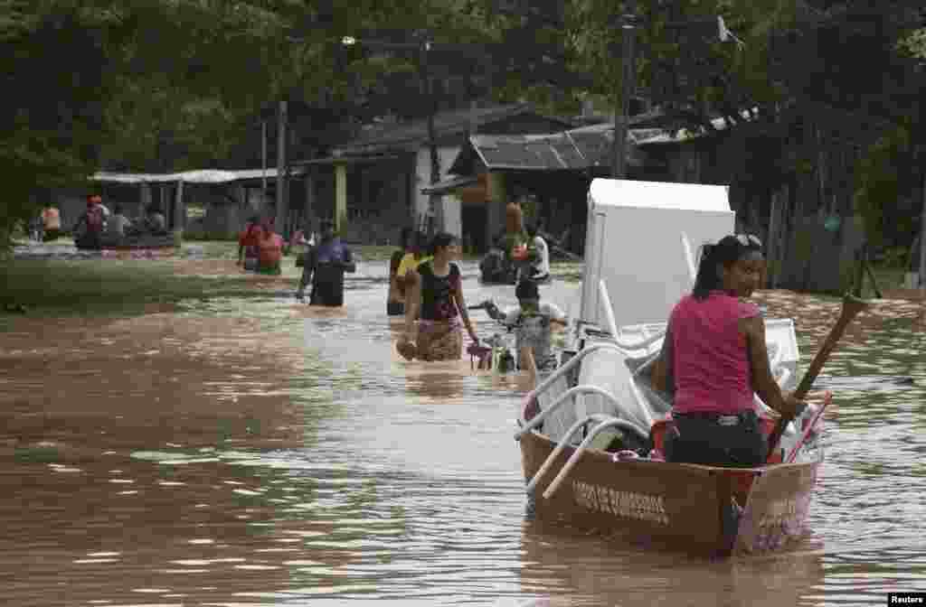 Residents and Civil Defense troops salvage belongings from homes flooded by the Acre river, which continues to rise from weeks of heavy rainfall in the region including northern Bolivia and eastern Peru, in Rio Branco, Acre state, March 9, 2014.