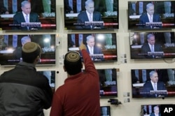 FILE - Israelis watch Prime Minister Benjamin Netanyahu address the U.S. Congress, in a shop in the city of Netivot, March 3, 2015.