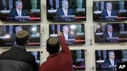 Warga Israel menonton pidato Perdana Menteri Benjamin Netanyahu di Kongres AS, dalam sebuah toko di Netivot (3/3). (AP/Tsafrir Abayov)