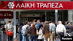 塞浦路斯各家銀行儲戶們早早地就在銀行門外和大街上排起長龍,等待著銀行開門取錢。