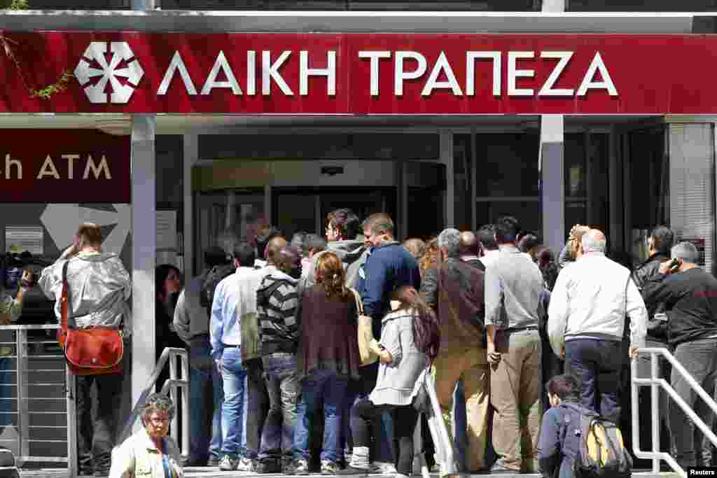 People wait to enter at a branch of Laiki Bank shortly after it opened in Nicosia, Cyprus, March 28, 2013. 