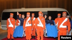 Chinese astronauts Jing Haipeng (left, in blue) and Chen Dong, who landed safely aboard China's Shenzhou 11 spacecraft's re-entry capsule in the northern region of Inner Mongolia, arrive in Beijing, China, Nov. 18, 2016.