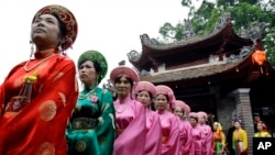 Vietnamese women wearing "ao dai" line up during Lang Pagoda Festival in Hanoi, Vietnam. Lang Pagoda was built in the 12th century during the Ly Dynasty. (AP Photo/Chitose Suzuki)