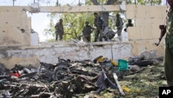 Pasukan Somalia memeriksa lokasi serangan bom mobil oleh militan al-Shabab di Mogadishu, Selasa (14/4).