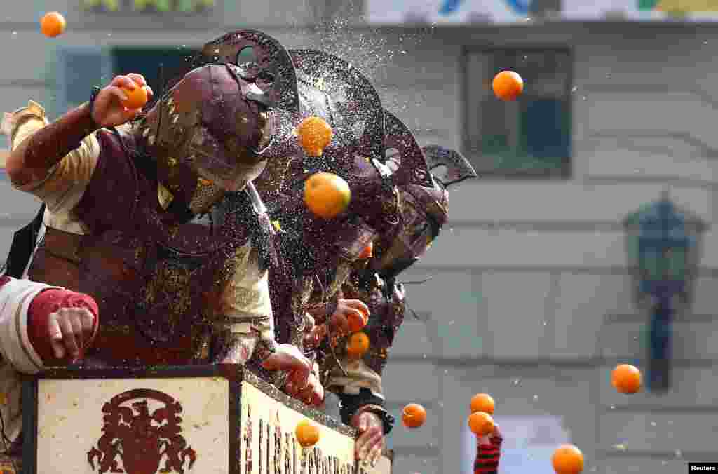 Members of a rival team are hit by oranges during an annual carnival orange battle in the northern Italian town of Ivrea.