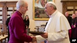 Pope Francis exchanges gifts with the Archbishop of Canterbury, Justin Welby, during a private audience at the Vatican on June 14, 2013.