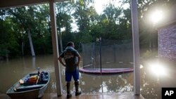 David Key looks at the back yard of his flooded home in Prairieville, La., Aug. 16, 2016. Key, an insurance adjuster, fled his home as the flood water was rising.