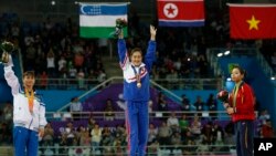 Oksana Chusovitina (chapda) 17-Osiyo o'yinlarida kumush medal bilan taqdirlanish marosimida, Janubiy koreya, 24-sentabr, 2016-yil.